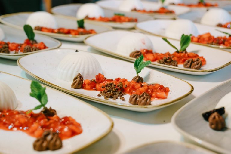 Dessert-Teller mit Erdbeeren, Sahne und Schokoladendekoration.